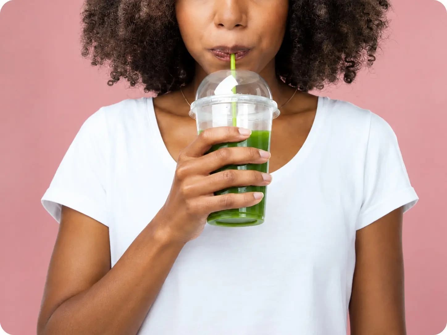 Personne dégustant un smoothie vert frais.